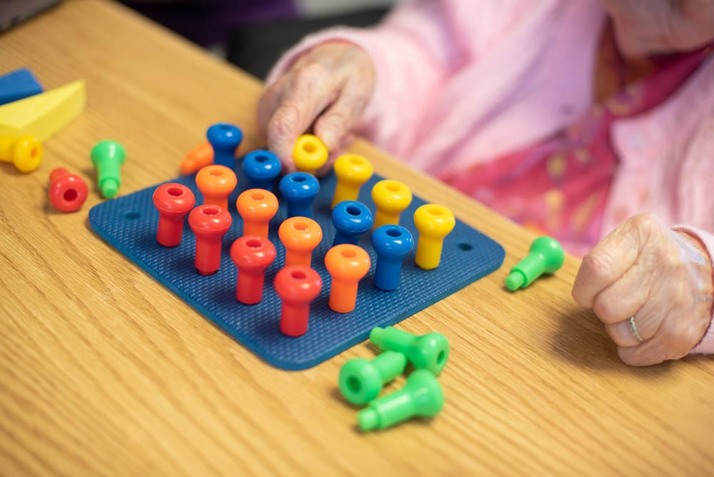Resident enjoying a colorful activity at a table