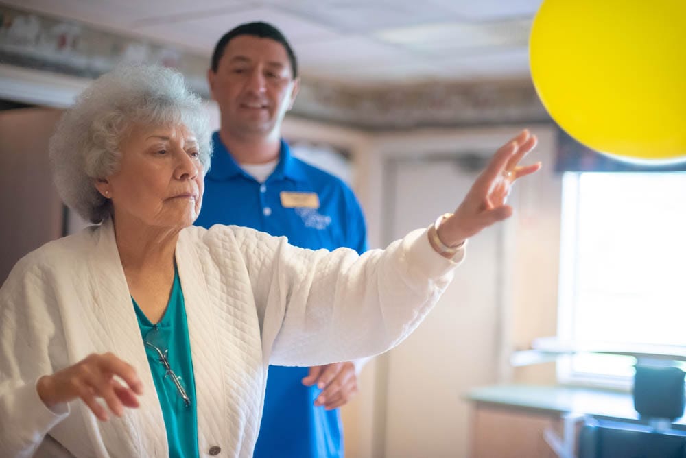 Resident playing with a balloon during an activity