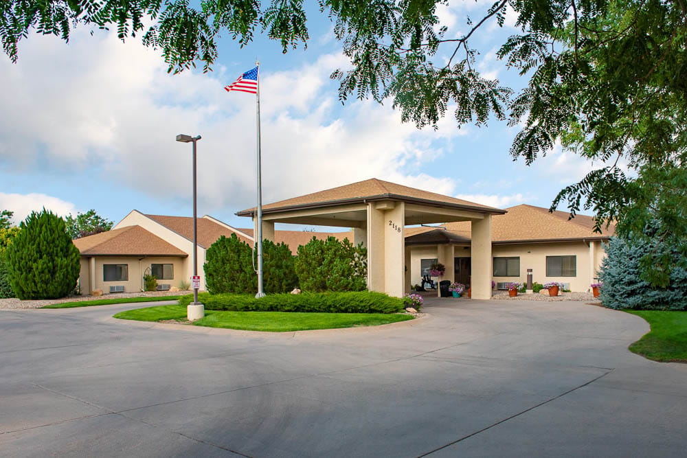 Exterior view of a senior living facility with a flag