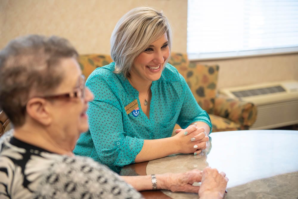 Staff member engaging with a resident at a table