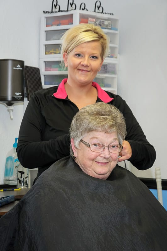 A resident getting a haircut from a stylist