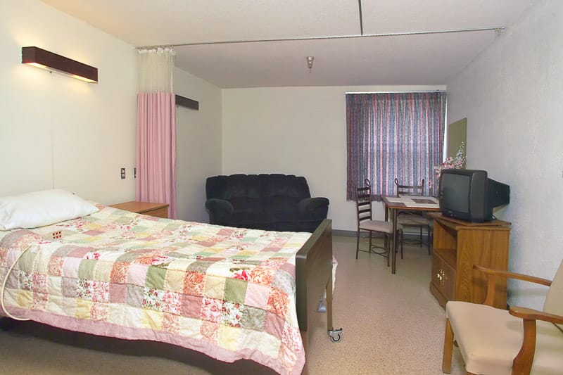 Private resident room with a bed and seating area