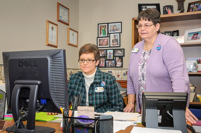 Staff assisting at a computer in an office setting