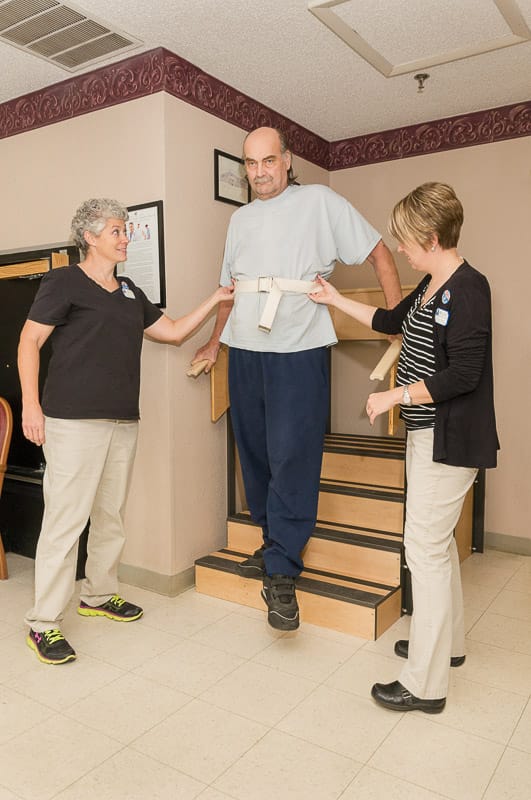 Staff assisting a resident with mobility on stairs