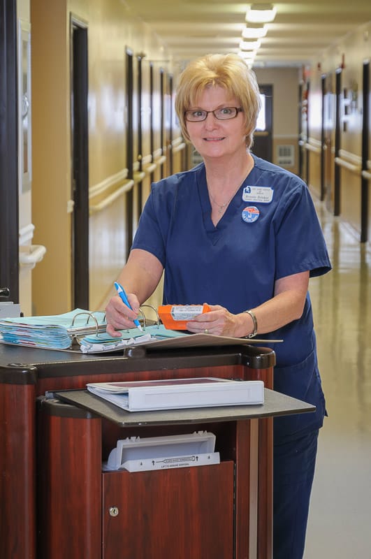 Staff member interacting with paperwork in a hallway