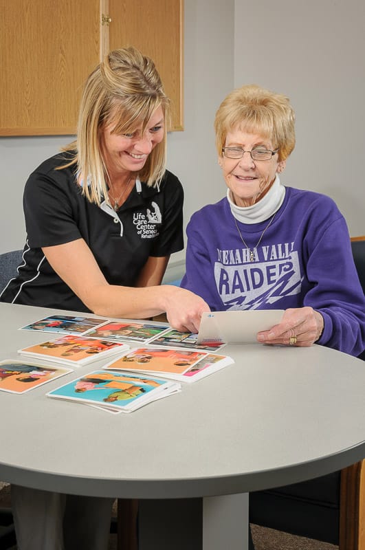 A staff member engaging with a resident at a table