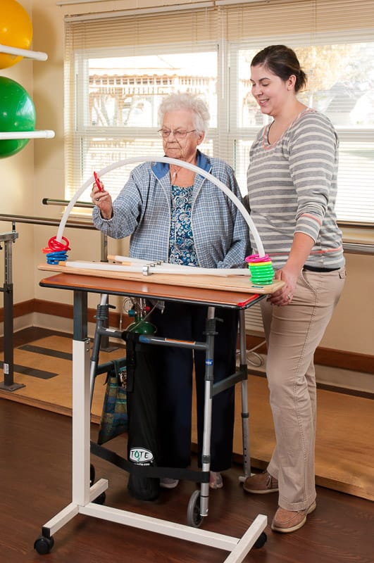 Therapist assisting a senior resident with an activity