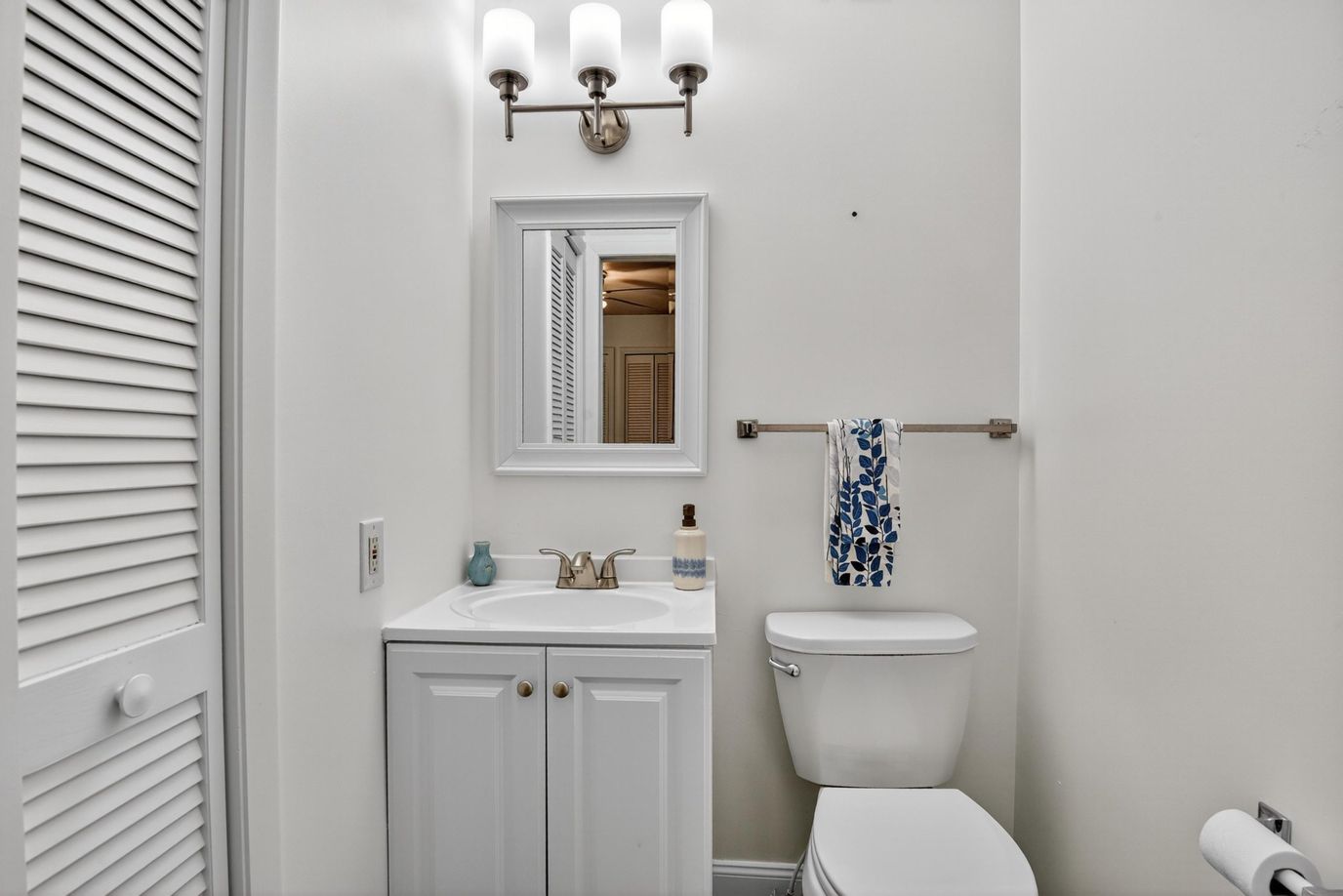 Bathroom with white cabinets and mirror