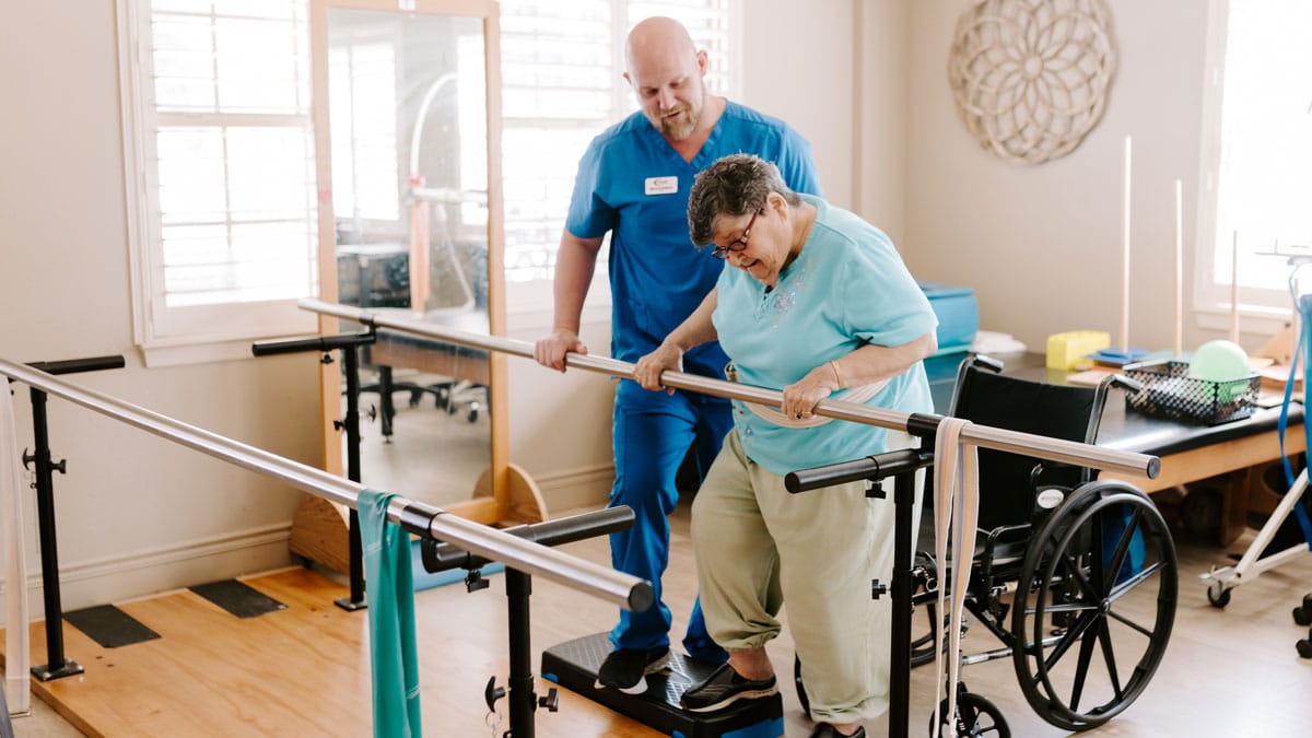 A caregiver assisting a resident with mobility exercises
