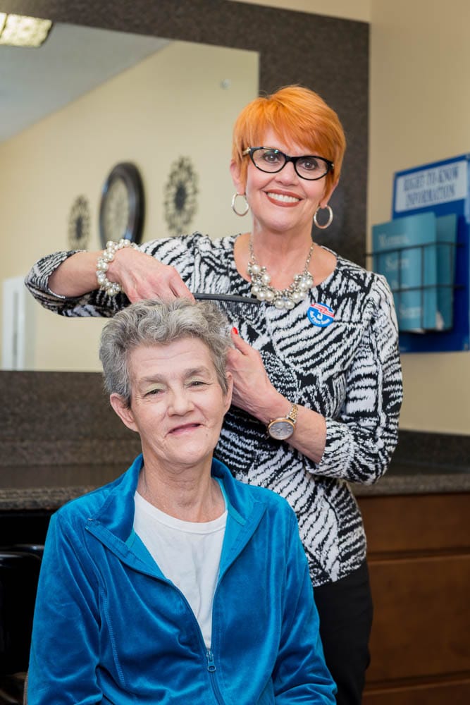 Resident receiving a haircut from the staff in a salon setting