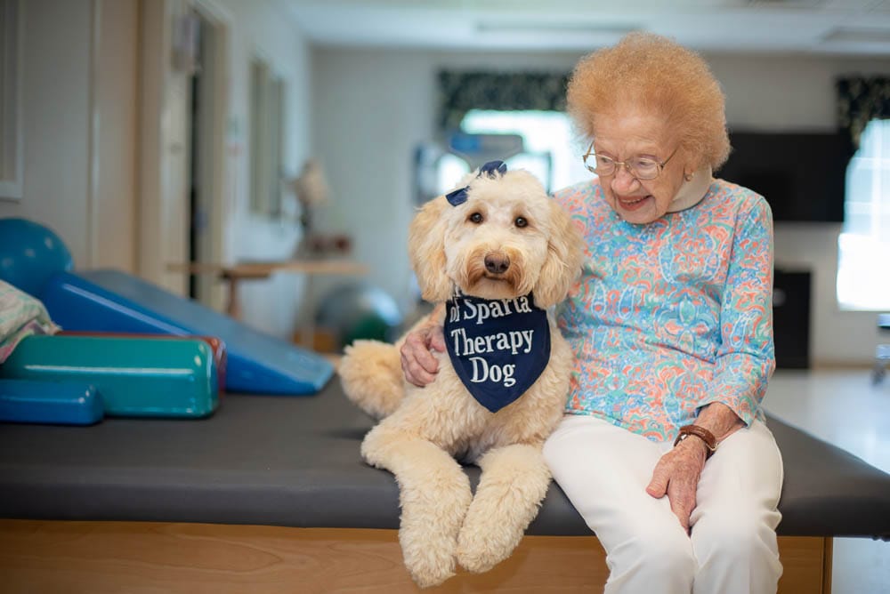 Senior resident with a therapy dog in a common area