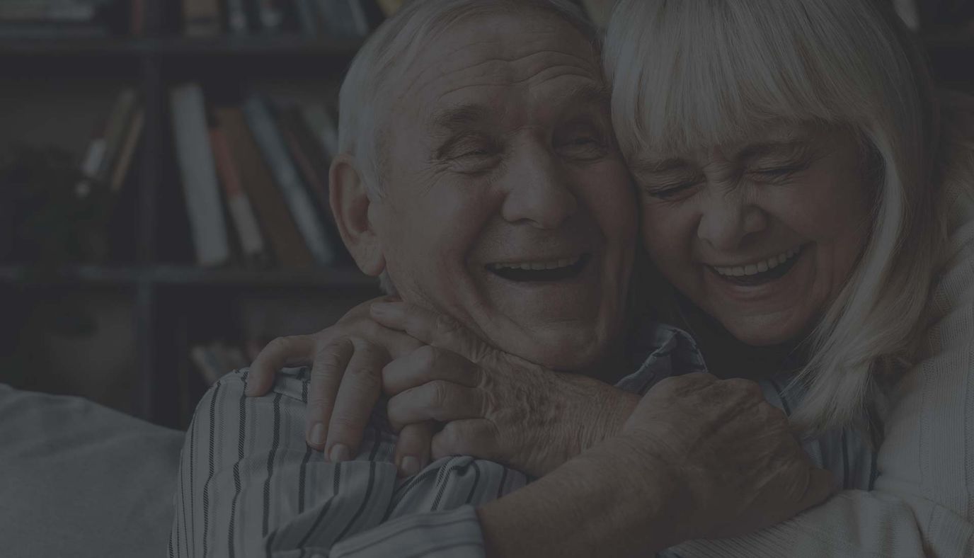A joyful elderly couple embracing in a cozy interior