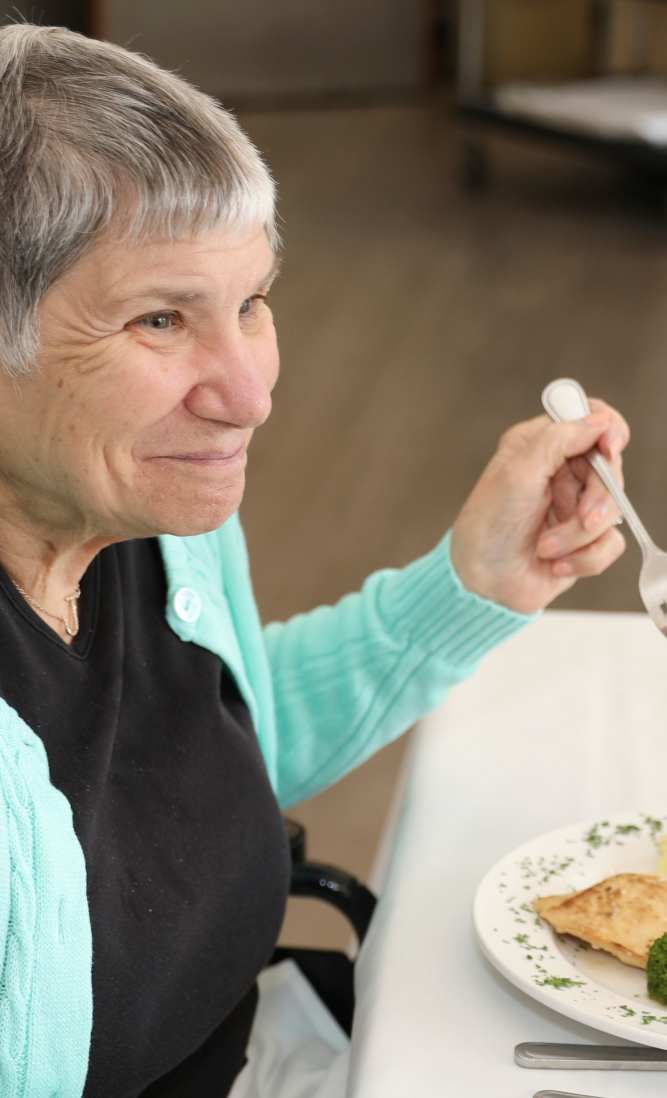 Resident enjoying a meal in the dining area