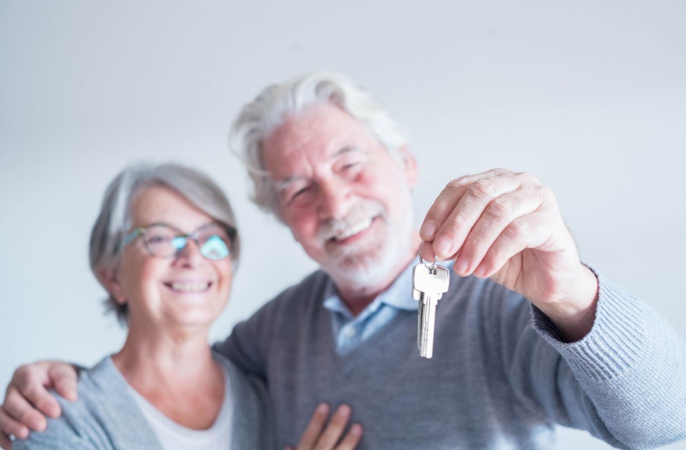 Senior couple smiling and holding keys