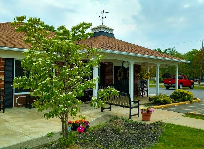 Exterior view of a senior living facility with trees and flowers