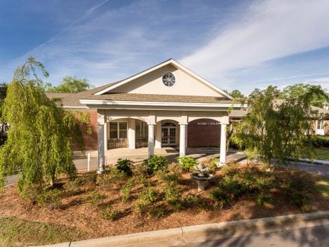 Exterior view of a nursing home facility with gardens