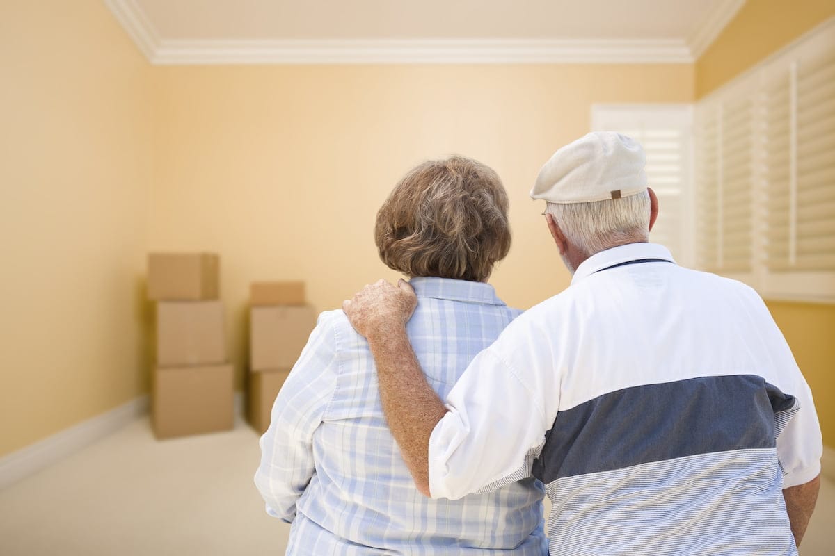Elderly couple facing a room with moving boxes
