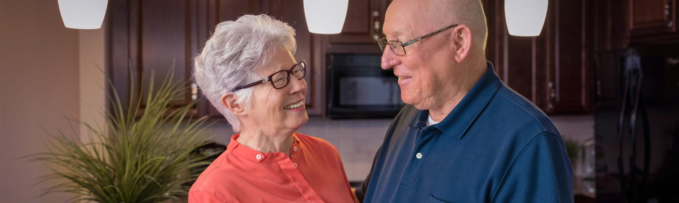 Couple smiling together in a bright kitchen