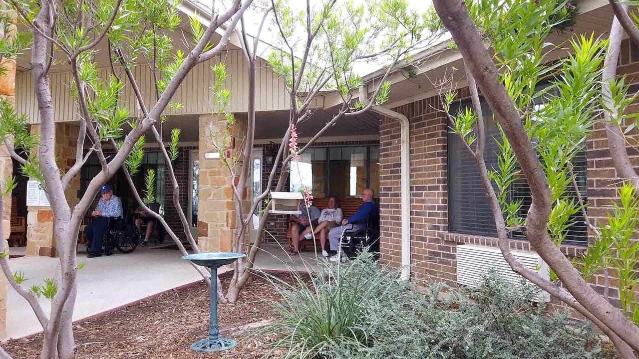 Residents relaxing outdoors in a shaded area