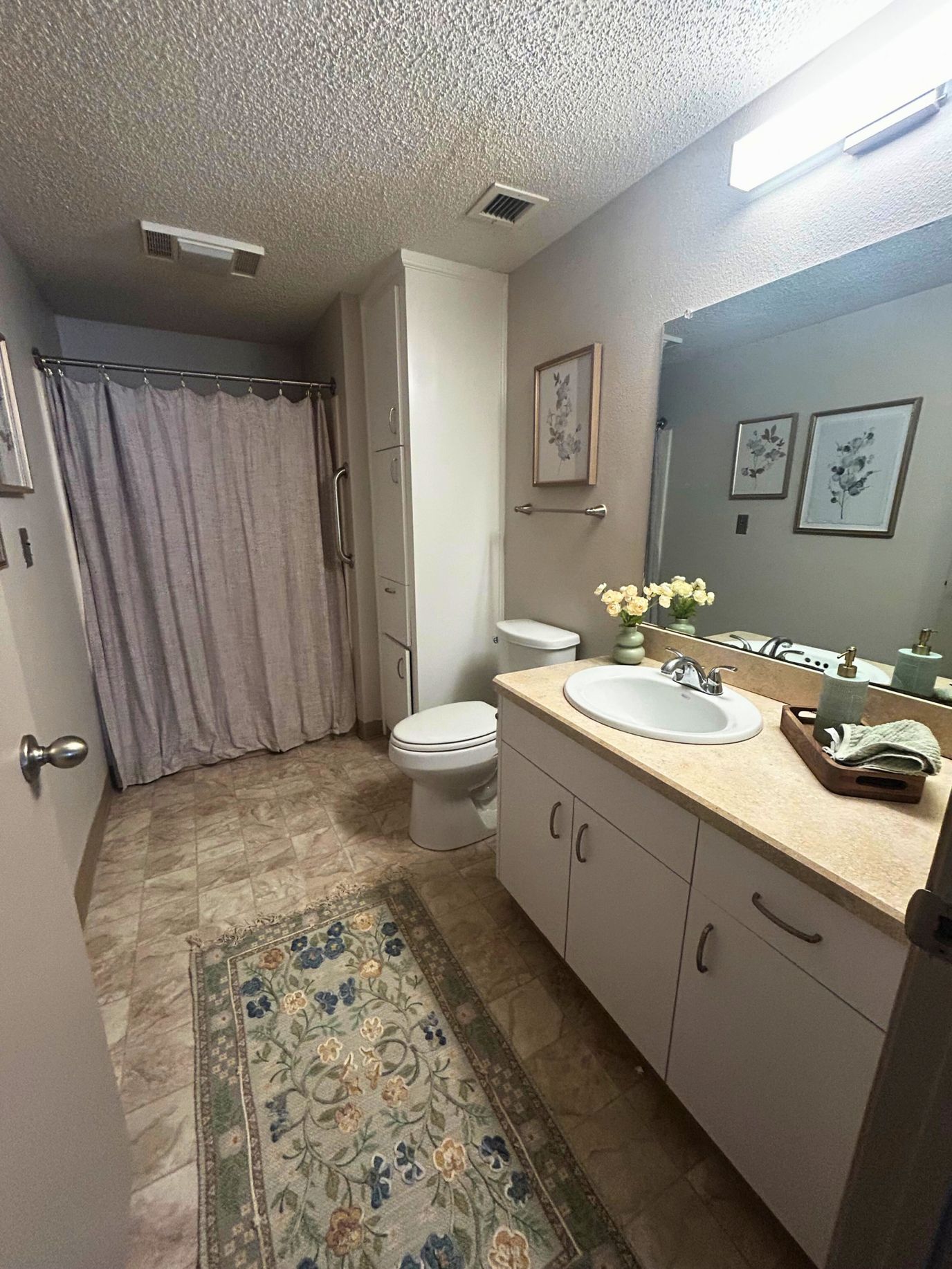 Well-lit bathroom with floral decor and clean amenities