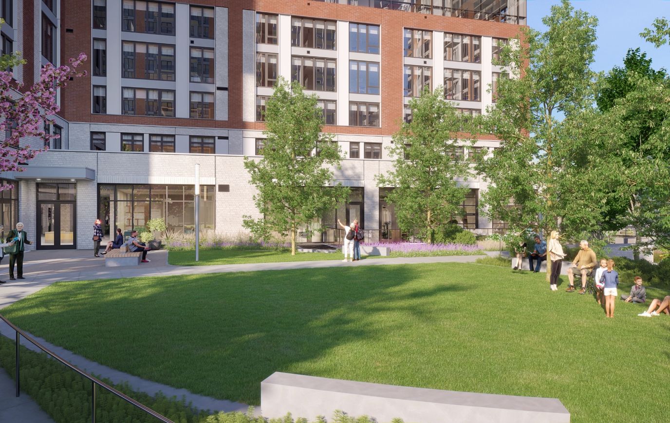 Residents enjoying an outdoor space with green grass and trees