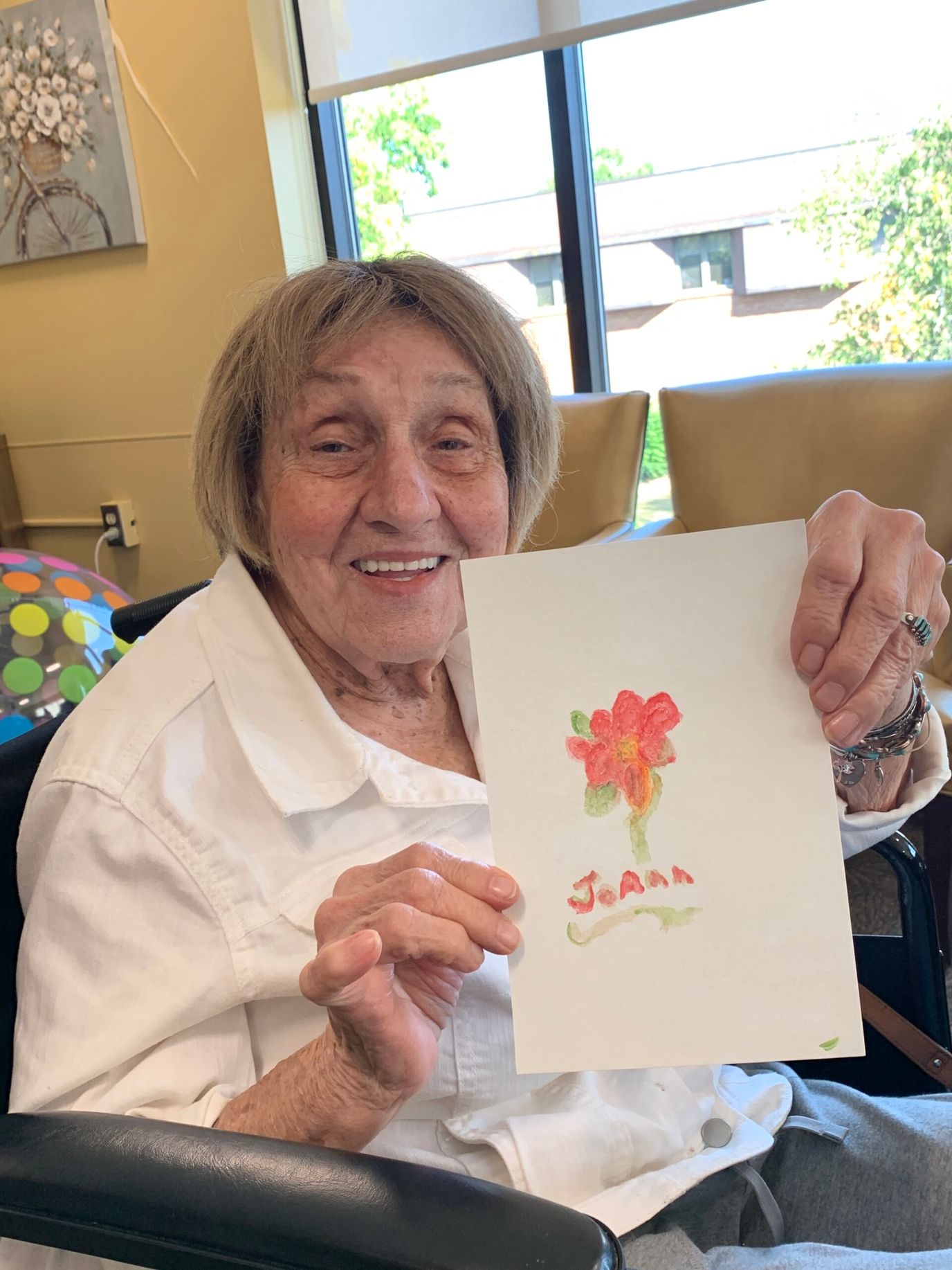 Resident showing her artwork in a common area
