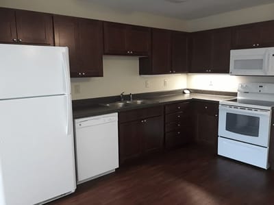 A kitchen area with appliances and cabinets