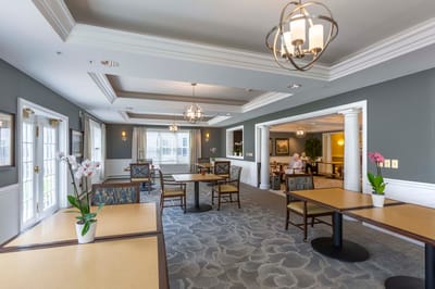 Bright common area with tables and residents