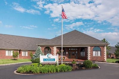 Exterior view of a senior living facility with flag