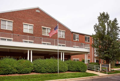 Exterior view of a senior living facility with flag