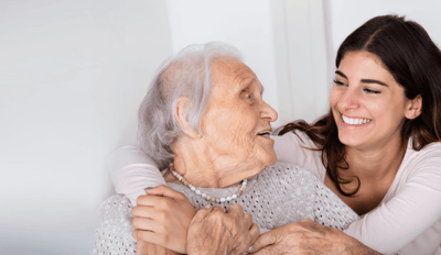 Interim HealthCare of Orlando, home care in Winter Park, FL — Elderly woman smiling at caregiver in a bright room