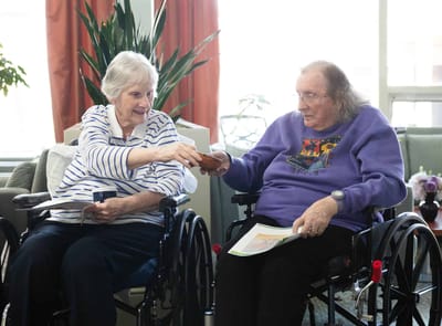 Maryville, Nursing Home in Beaverton, OR — Two women in wheelchairs interacting in a common area