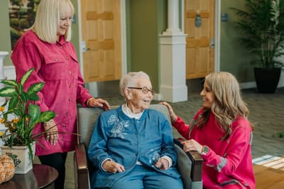 Residents interacting with staff in a cozy lounge