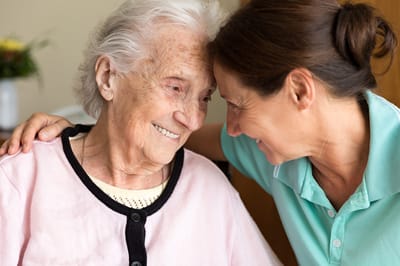 Diversicare of Riverchase, Nursing Home in Birmingham, AL — Caregiver interacting affectionately with a senior resident