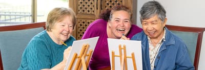 Residents enjoying a painting activity with staff.