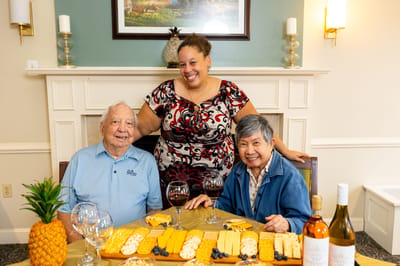 Residents enjoying a snack with staff in a common area