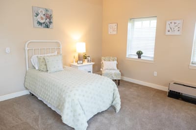 Cozy private resident room with bed and chair
