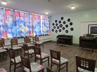 Magnolia Adult Day Care, assisted living in Fort Lee, NJ — Activity room with chairs, curtains, and musical instruments