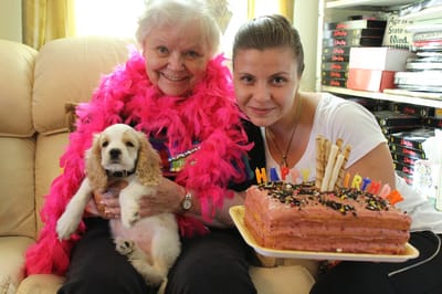 Resident celebrating a birthday with cake and a dog