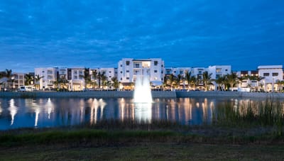 Facility building exterior by a serene lake at dusk