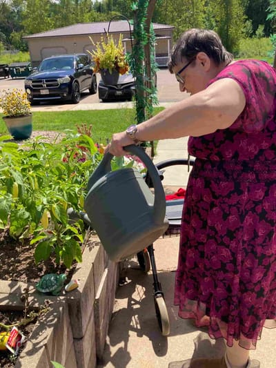 Resident watering plants in a garden setting