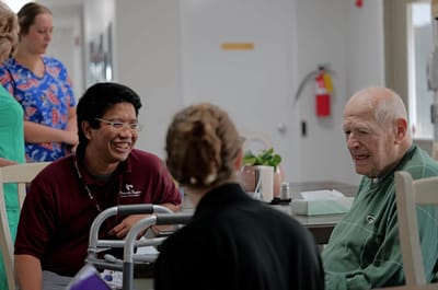 Staff member engaging with an elderly resident in a common area