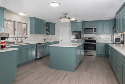 Modern kitchen interior with teal cabinets and stainless appliances