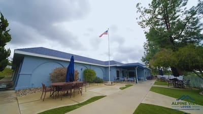 Exterior view of Alpine View Lodge with patio seating and flag