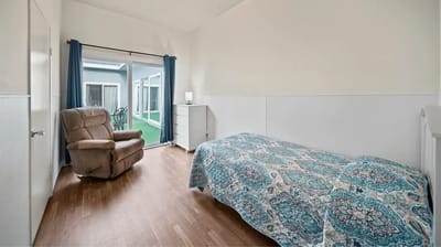 Spacious resident room with a recliner and bed