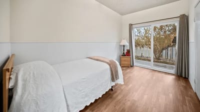 A private resident room with a bed and sliding glass door