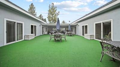 Outdoor patio area with seating and green turf