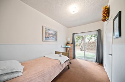 A private resident room with a bed and patio access