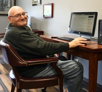 Resident using a computer at a desk in a common area