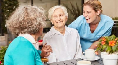Residents enjoying conversation outdoors with staff